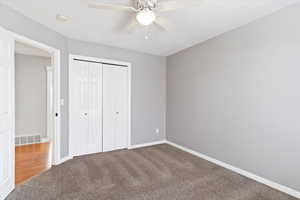 Unfurnished bedroom featuring carpet floors, a closet, and ceiling fan