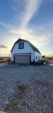 Property exterior at dusk with an outdoor structure and a garage