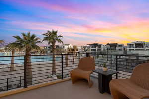 Balcony at dusk featuring a water view