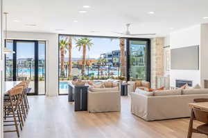 Living room with ceiling fan, floor to ceiling windows, and light hardwood / wood-style flooring