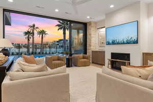 Living room featuring ceiling fan and a wall of windows