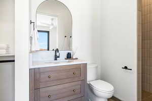 Bathroom featuring vanity, ceiling fan, and toilet