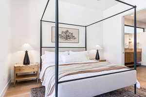 Bedroom featuring ensuite bath, hardwood / wood-style floors, and sink