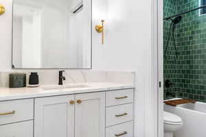 Full bathroom with vanity, toilet, and tiled shower / bath