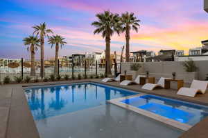 Pool at dusk with an in ground hot tub