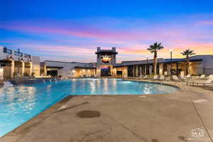 Pool at dusk featuring a patio