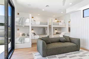 Bedroom featuring light hardwood / wood-style flooring and wooden walls