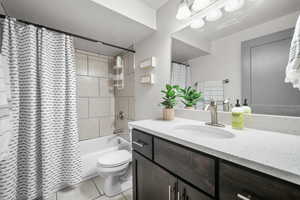 Full bathroom featuring tile patterned floors, vanity, shower / bath combination with curtain, and toilet