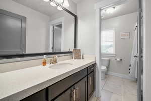 Bathroom featuring tile patterned floors, vanity, and toilet