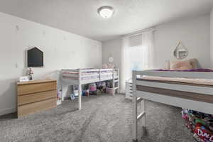 Carpeted bedroom featuring a textured ceiling