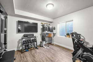 Workout room with hardwood / wood-style floors and a textured ceiling