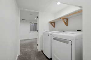 Laundry area with washer and clothes dryer and carpet floors