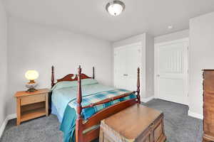 Bedroom featuring dark carpet and a closet