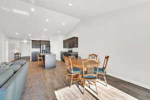 Dining area with lofted ceiling, light wood-type flooring, and sink