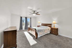 Carpeted bedroom featuring ceiling fan