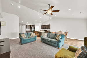 Living room featuring ceiling fan, lofted ceiling, and sink