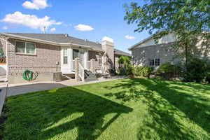 Rear view of house with a patio area and a yard