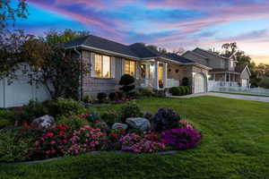 View of front of property featuring a lawn and a garage