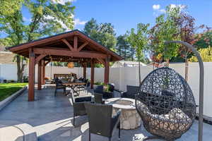 View of patio / terrace featuring a gazebo and an outdoor living space with a fire pit