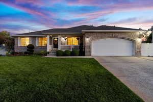 Ranch-style home featuring a lawn and a garage