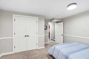 Bedroom featuring light colored carpet and a closet