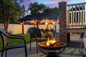 Patio terrace at dusk featuring a gazebo and a fire pit