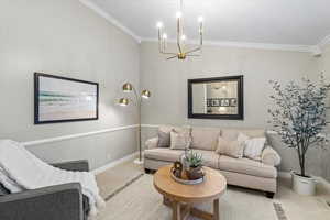 Living room featuring carpet flooring, crown molding, and a chandelier