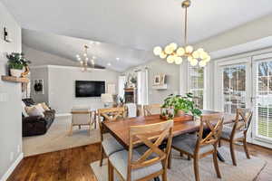 Dining space featuring a chandelier, wood-type flooring, and lofted ceiling