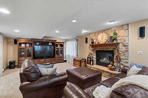 Living room with a stone fireplace and carpet floors