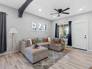 Living room featuring ceiling fan, a healthy amount of sunlight, and light wood-style flooring