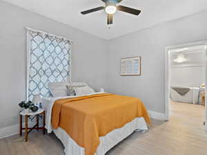 Bedroom with ceiling fan and light wood-style flooring