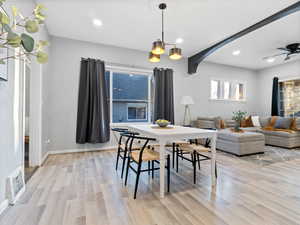 Dining space with ceiling fan with notable chandelier and light wood-style flooring