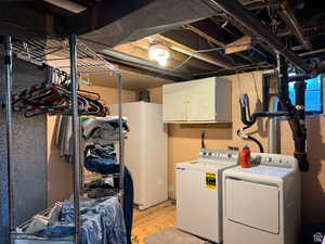 Washroom featuring washer and clothes dryer and cabinets