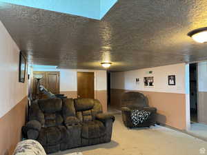 Living room featuring carpet and a textured ceiling