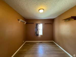 Empty room featuring hardwood / wood-style floors and a textured ceiling