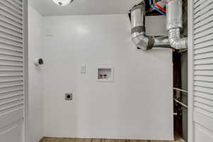 Laundry area featuring hookup for an electric dryer, hookup for a washing machine, and light hardwood / wood-style flooring