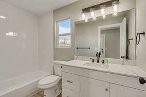 Full bathroom featuring vanity, shower / bathtub combination, and toilet