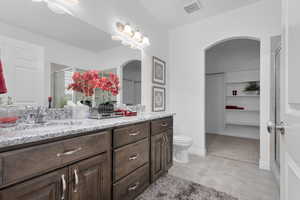 Bathroom featuring vanity, an enclosed shower, and toilet