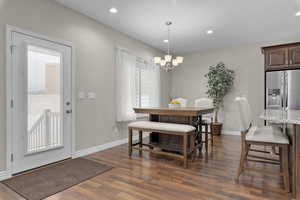 Dining area featuring plenty of natural light, dark hardwood / wood-style floors, and a notable chandelier