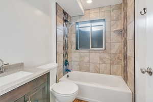 Full bathroom featuring vanity, toilet, and tiled shower / bath