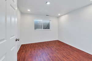 Empty room featuring dark hardwood / wood-style floors