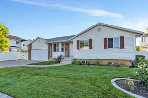 View of front of home with a garage and a front lawn