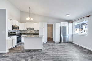 Kitchen featuring white cabinetry, appliances with stainless steel finishes, and tasteful backsplash