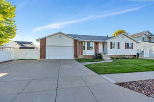 Ranch-style house featuring a front yard and a garage