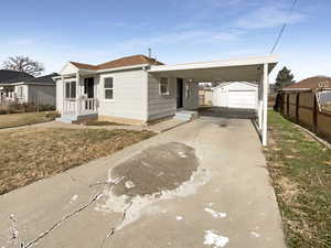 View of front of home with an outbuilding and a carport