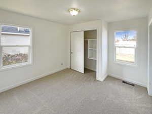 Unfurnished bedroom featuring a closet and light colored carpet