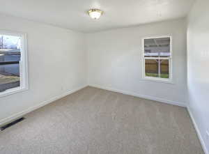 Unfurnished room with carpet flooring and a healthy amount of sunlight