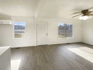 Interior space with beam ceiling, ceiling fan, and dark hardwood / wood-style floors