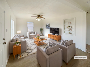 Living room with built in shelves, ceiling fan, light hardwood / wood-style flooring, and a textured ceiling