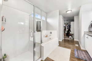 Bathroom featuring vanity, independent shower and bath, and hardwood / wood-style flooring